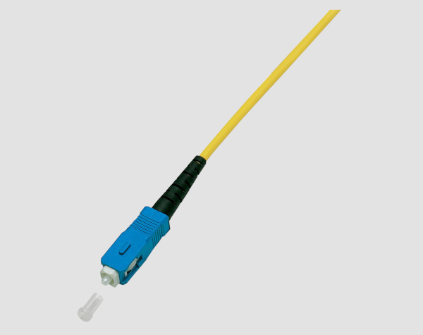 Yellow fiber optic patch cable with blue plug and removed protective cap.