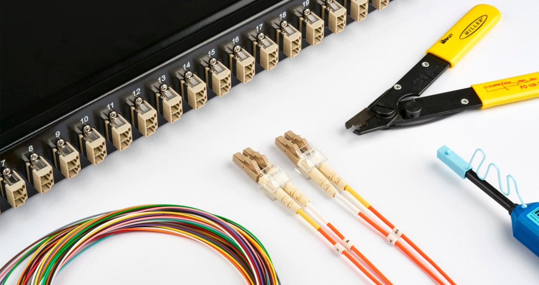 Network components and tools, including a patch panel, fiber optic patch cables, colored cables and a stripping tool.